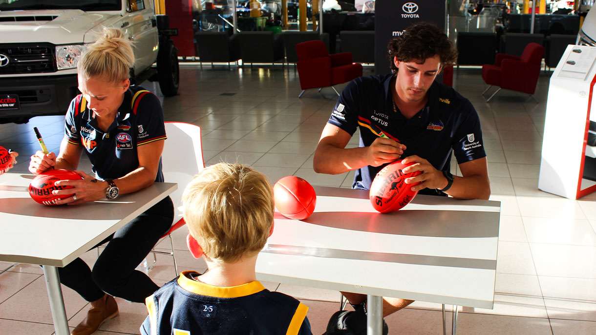 Adelaide Crows footballers signing footballs