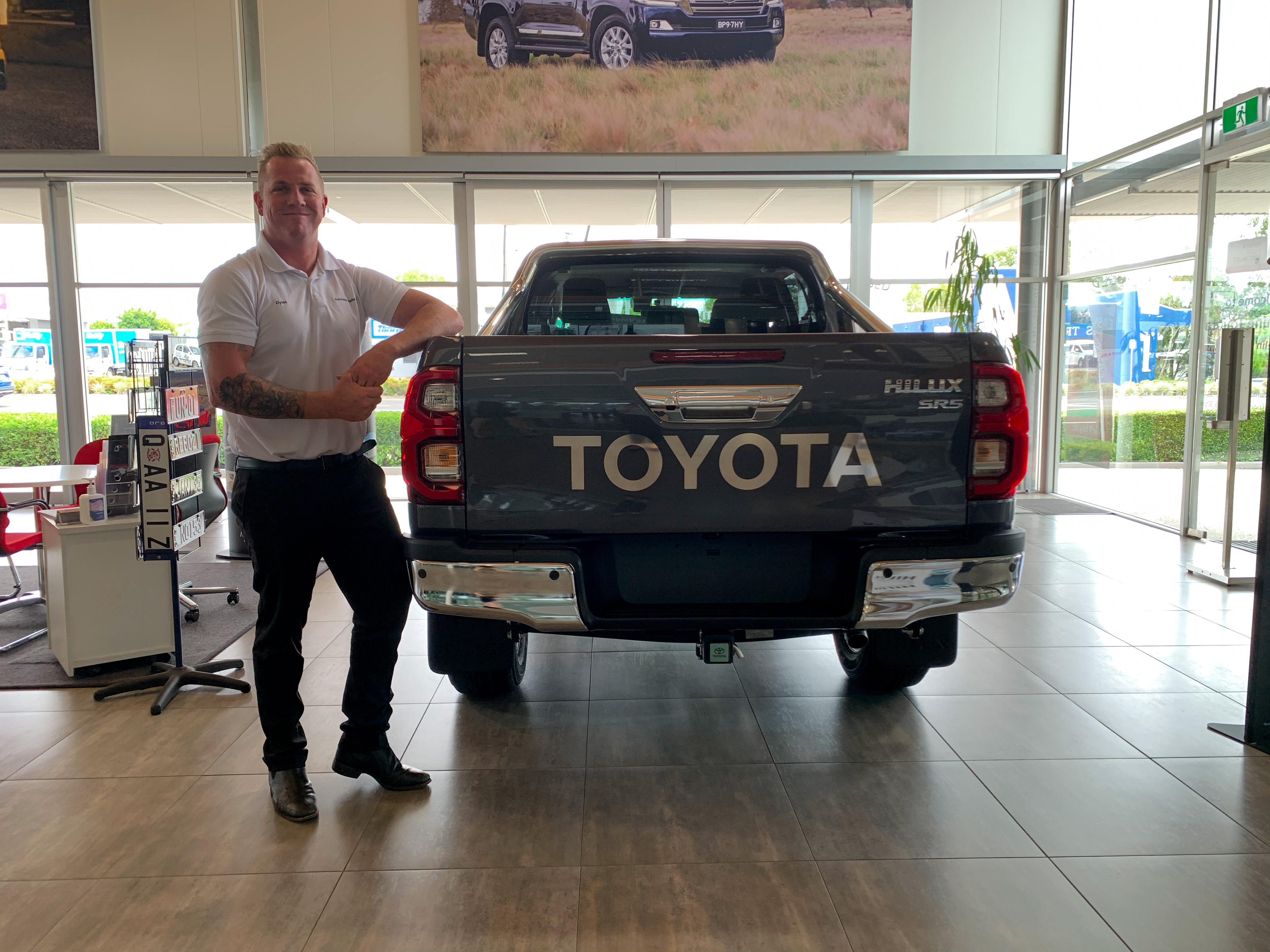 Dylan with a HiLux SR5 in graphite - ask us today at Sunshine Toyota on the Sunshine Coast